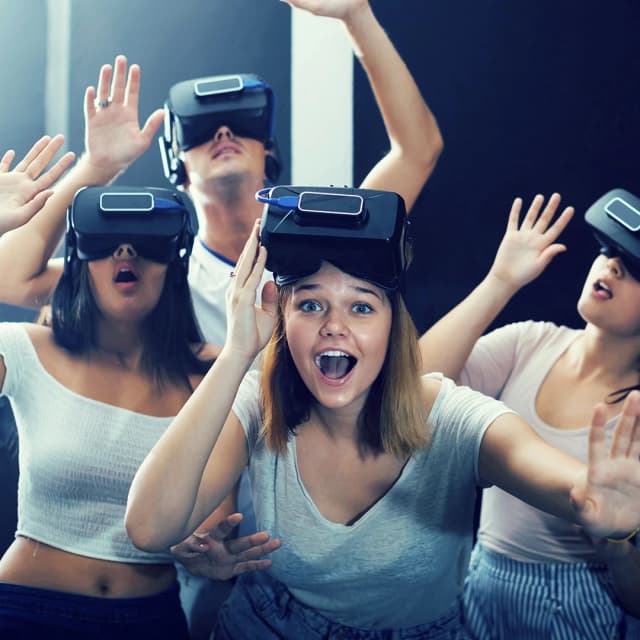 Gruppe junger Menschen mit VR-Brillen erlebt ein Virtual-Reality-Spiel bei 7th Space Dresden, voller Action und Begeisterung