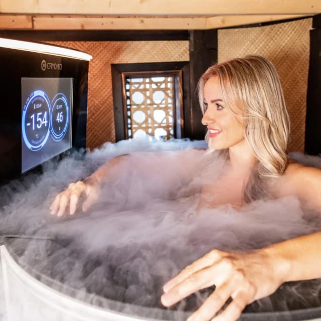 Frau in einer Kryotherapie-Kammer im Schwebebad Dresden, moderne Wellness-Anwendung mit -154 Grad auf digitalem Display